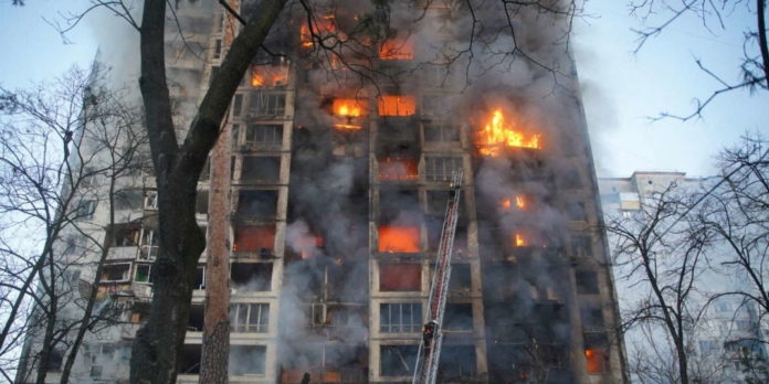 Rescuers work next to a residential building damaged by shelling in Kyiv